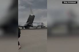 image Passengers Flee Smoking Jet On Emergency Slide After Apparent Landing Gear Problem At Denver Airport