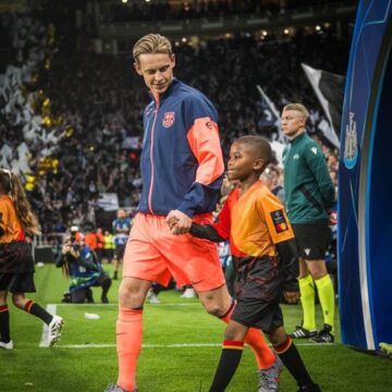 WhatsApp Image 2025-09-20 at 10.46.14_38e90a52 Football As A Unifier: Barcelona Midfielder Frenkie De Jong Walking On The Pitch With A Young Fan