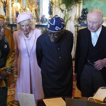 President Tinubu And First Lady Remi Tinubu Being Shown A Display Of Objects From The Royal Collection Trust In The Green Drawing Room At Windsor Castle.