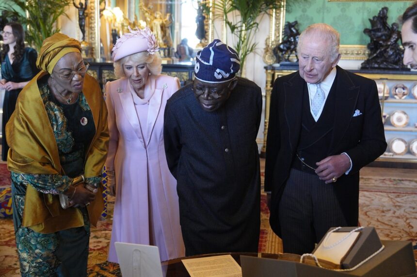 President Tinubu And First Lady Remi Tinubu Being Shown A Display Of Objects From The Royal Collection Trust In The Green Drawing Room At Windsor Castle.